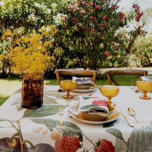 Fruit Love tablecloth with a border of fruit, leaves and flowers around a light center.
