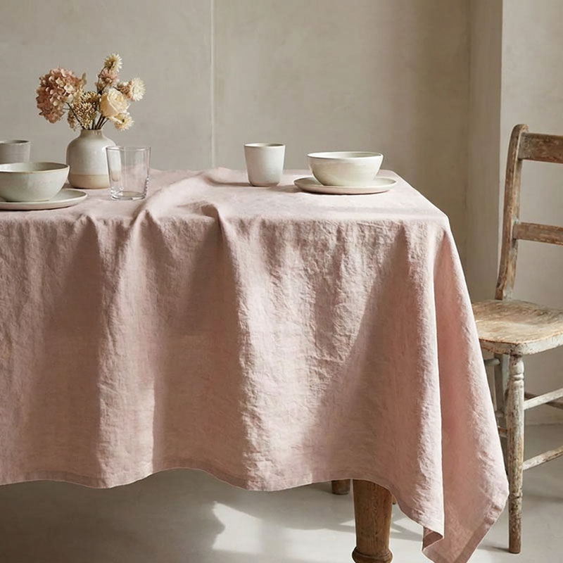 Linen tablecloth Vintage Old Rose-la-bottega-di-casa Dusty pink Vintage linen tablecloth set on a table with light ceramic bowls and cups, a glass, and a vase of dried pink and cream flowers