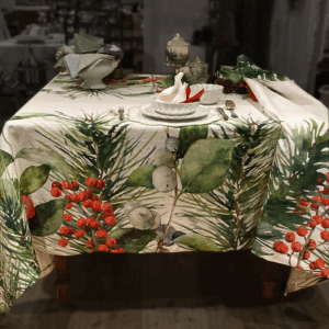Tovaglia Foglie e Bacche di La Bottega di Casa con foglie verdi, bacche rosse e dettagli grigi su fondo chiaro, abbinata a piatti bianchi.